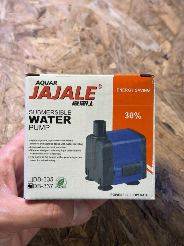 משאבת מים טבולה JAJALE (דגם DB-337) באריזה לבנה וכתומה, מוצגת ביד. חיסכון באנרגיה 30%.