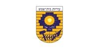 סמל עיריית בית שמש: שמש, ספר, גלים, פטיש, את חפירה וחיטה על רקע לבנים.